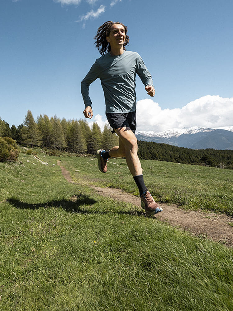 Uomo che corre con scarpe da trail Hoka Challenger 8