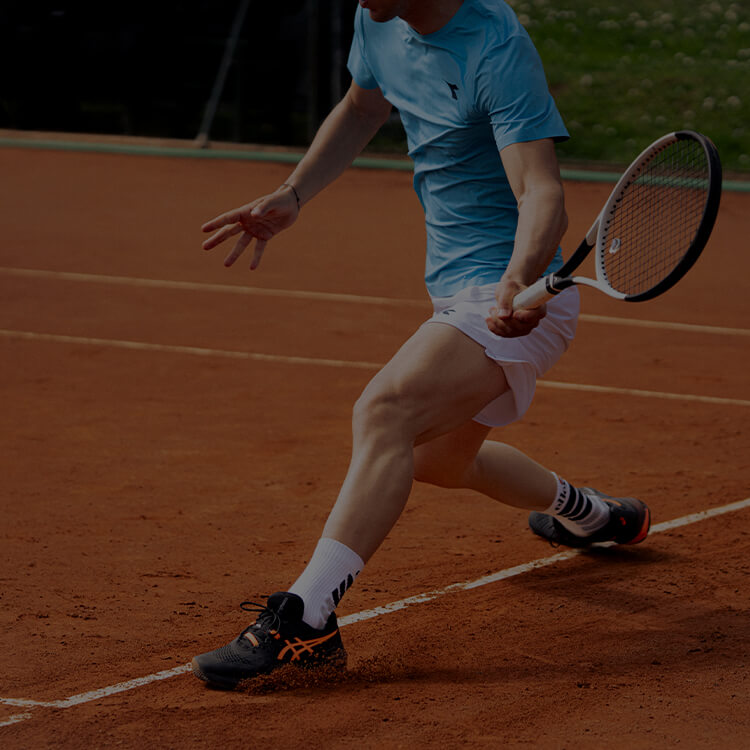 Ragazzo che gioca a tennis con focus sulle scarpe