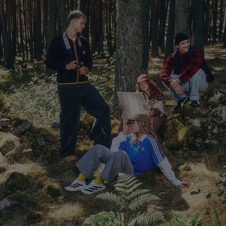 Gruppo di ragazzi nel chill in un bosco, vestiti con abbigliamento athleisure autunnale ed invernale.