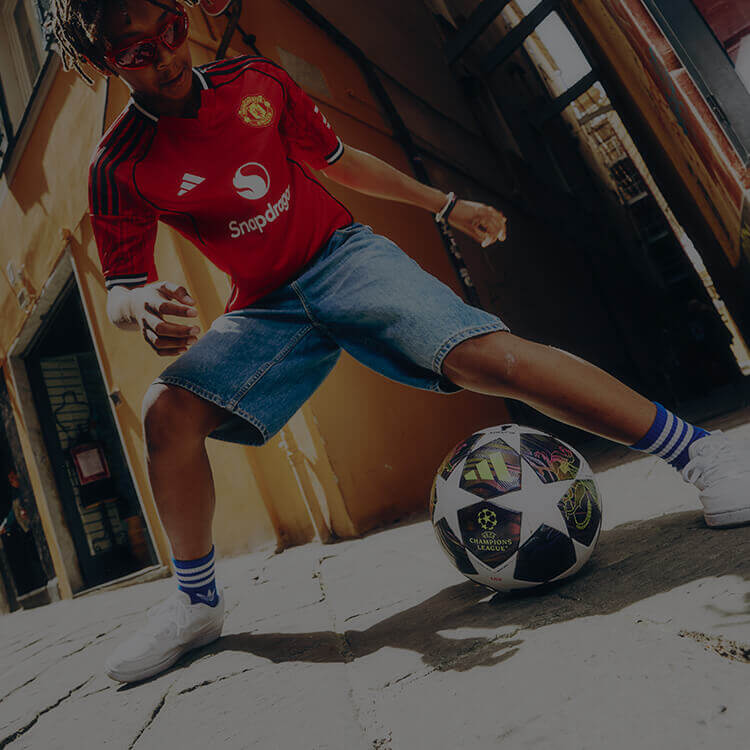 Ragazzo che gioca a calcio per le vie della citt&agrave;