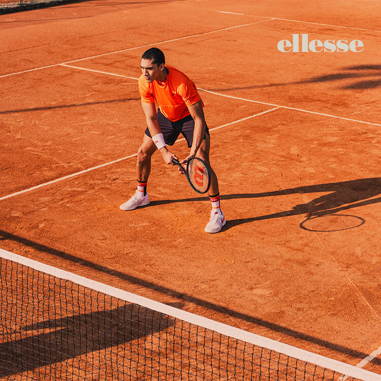 Ragazzo in campo vestito con abbigliamento tennis di Ellesse