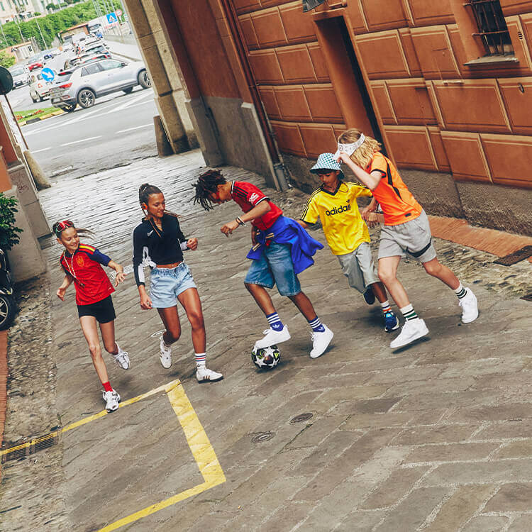 Gruppo di bambini che giocano a calcio per le vie del paese