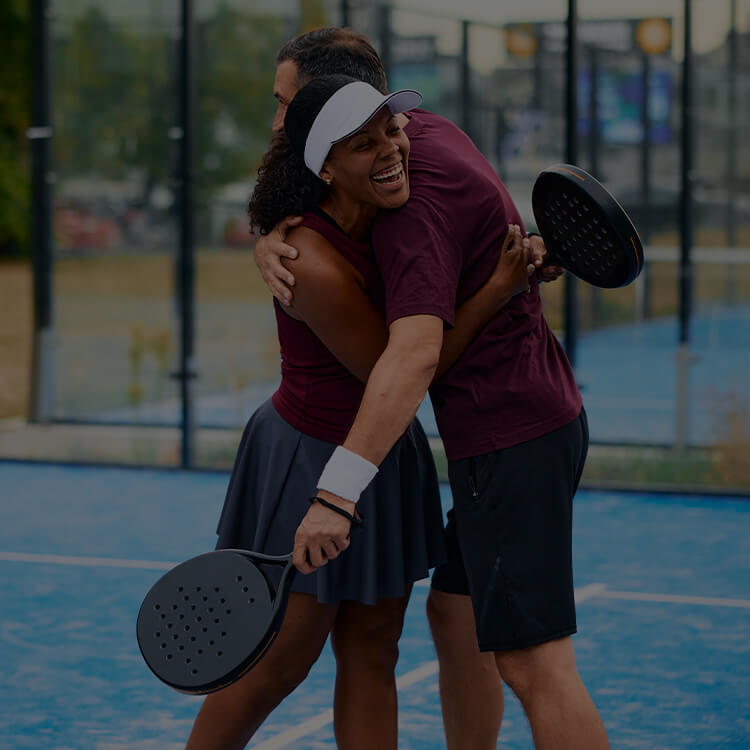 Due ragazzi che si abbracciano in campo dopo essersi sfidati ad una partita di padel